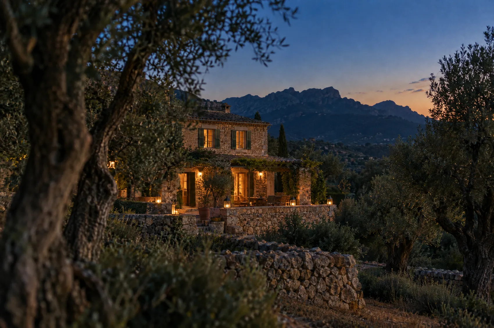 Illustratives Motiv: eine mallorquinische Finca zwischen Olivenbäumen in der Abenddämmerung
